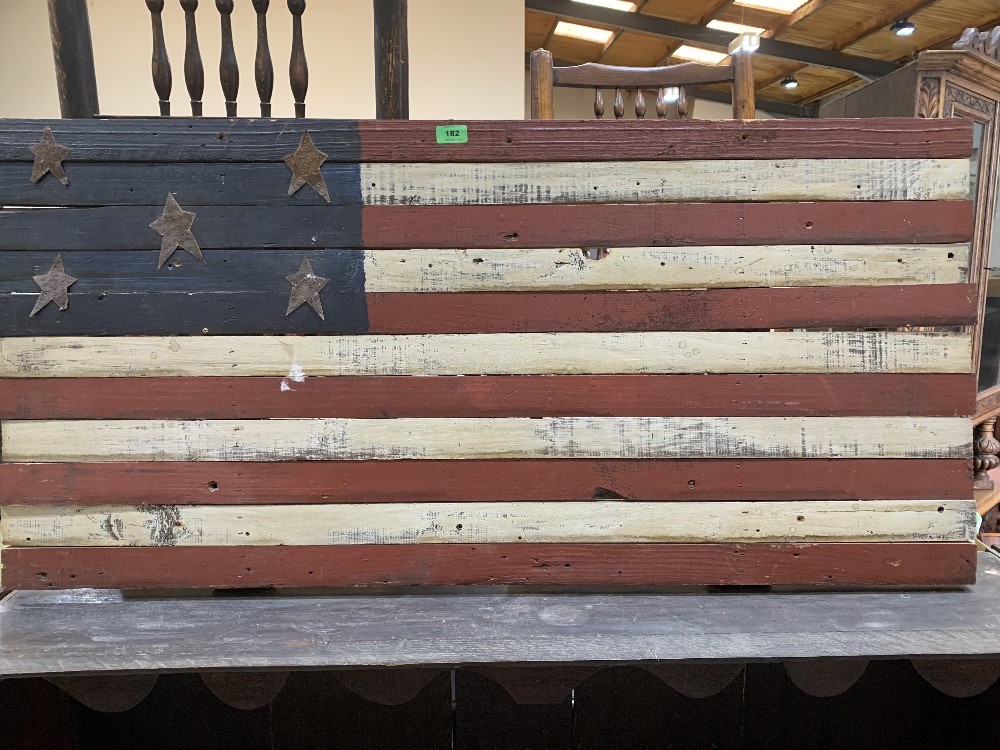 A stars and stripes painted wood panel. 23' x 48'