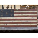 A stars and stripes painted wood panel. 23' x 48'