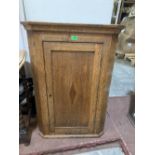 An oak hanging corner cupboard. 38' high, with key