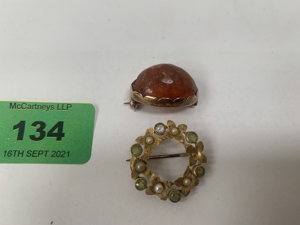 A peridot and split pearl gold brooch and a gold set amber brooch