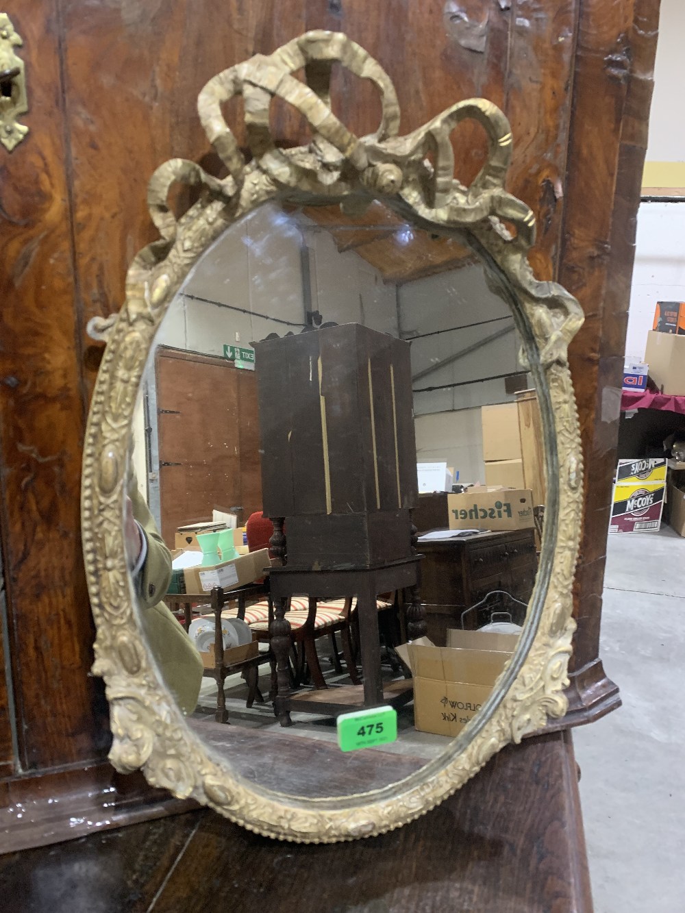 A 19th century gilt gesso oval looking glass, with ribbon-tie moulded frame. Plate later. 18½' high