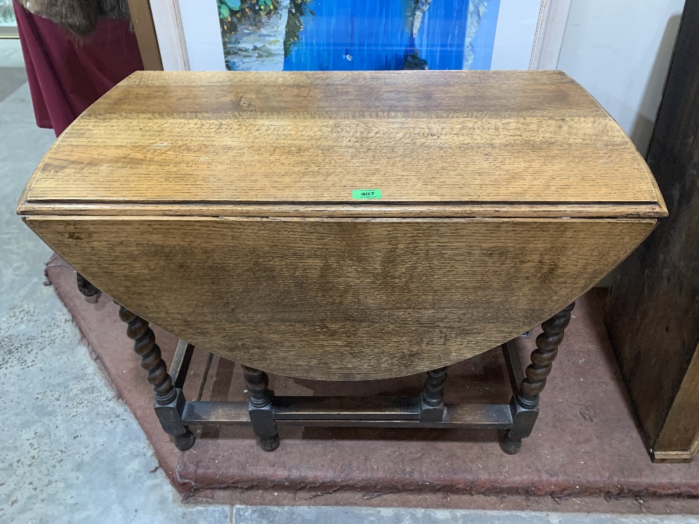 An oak dropleaf table on barleytwist legs. 36' wide