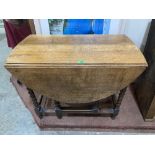 An oak dropleaf table on barleytwist legs. 36' wide