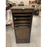 An oak filing cabinet enclosed by a tambour shutter. 44' high. Requires some renovation