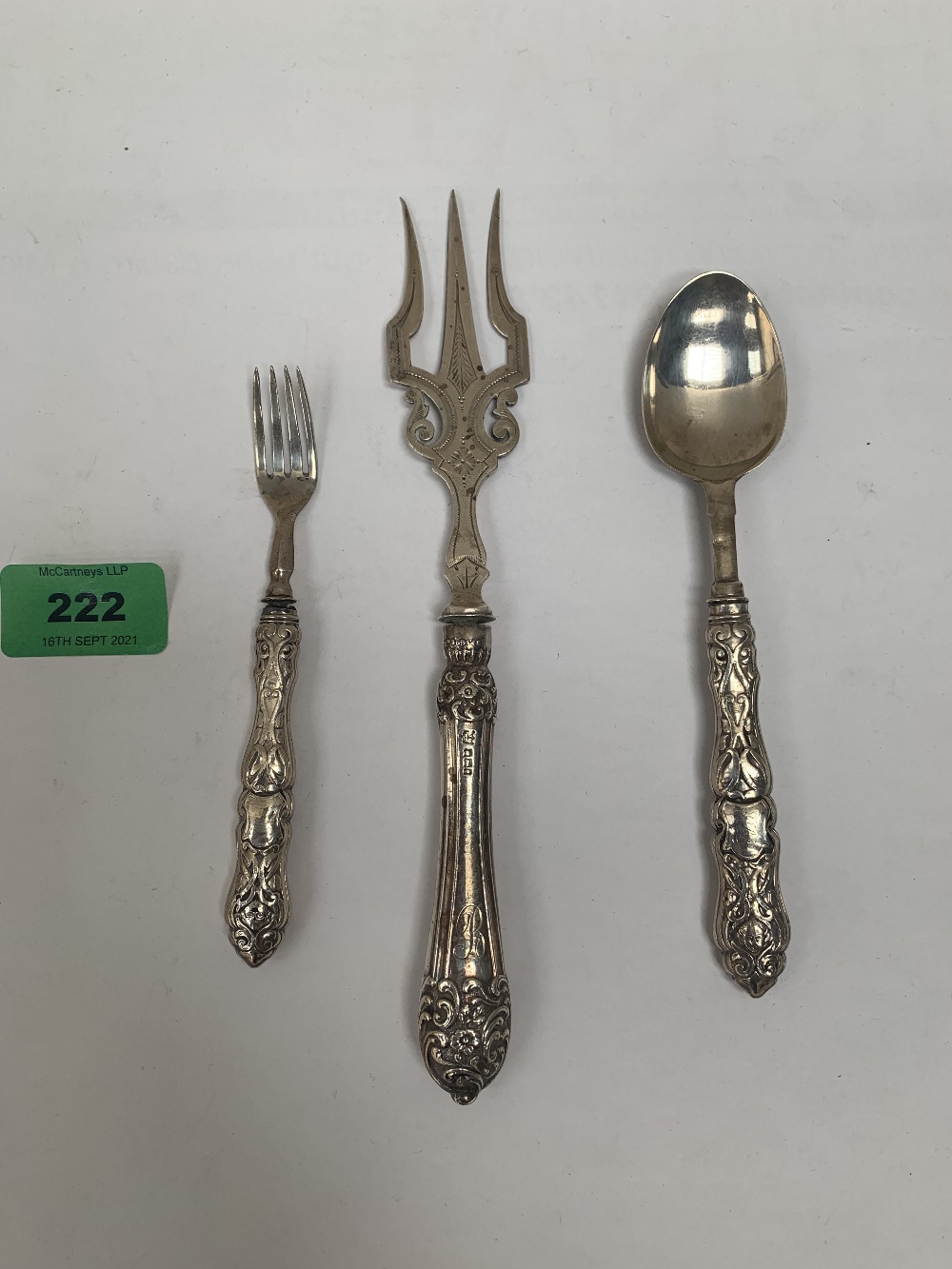 A silver fish fork; a silver spoon and a silver cake fork. (3) Handles loaded