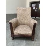 A Regency mahogany and upholstered armchair on ring and leaf moulded legs. Castors lacking, loss