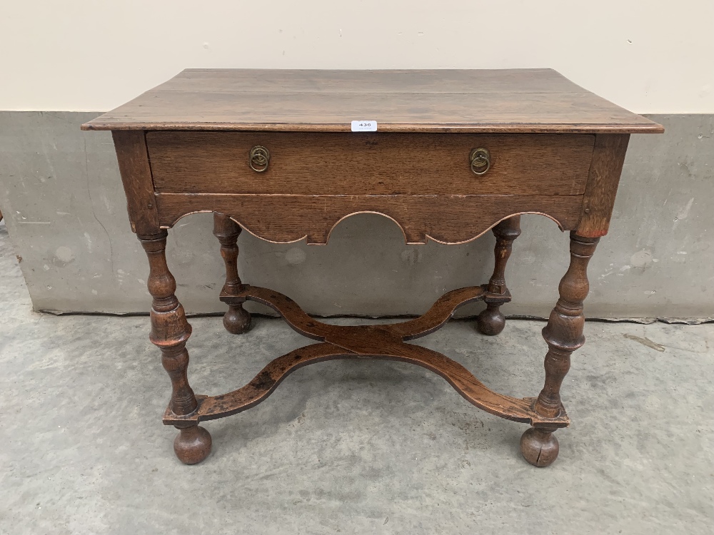 An early 18th century joined oak side table, the moulded top over a frieze drawer, raised on cup and