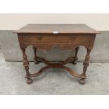 An early 18th century joined oak side table, the moulded top over a frieze drawer, raised on cup and