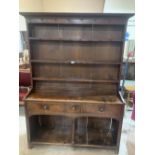 An 18th century oak potboard dresser, the raised rack with three shelves and iron hooks, the base