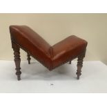 A George IV mahogany gout stool with leather upholstered top on turned tapered legs