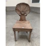 A 19th century mahogany hall chair, the back carved as a scallop shell, raised on ring turned legs