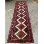 An eastern carpet runner, the white field with eight stepped lozenges. 124' x 38'