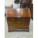 A George III writing bureau, the sloping fall over four long graduated drawers on bracket feet.