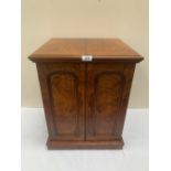 A Victorian walnut humidor cabinet, the pair of arch panel doors enclosing two drawers and a recess,