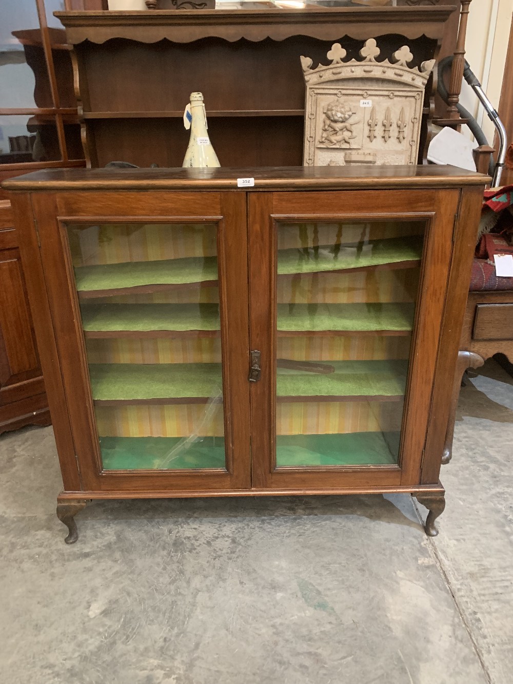 A mahogany bookcase enclosed by a pair of glazed doors. 44' wide. Glass pane cracked