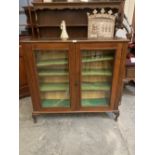A mahogany bookcase enclosed by a pair of glazed doors. 44' wide. Glass pane cracked