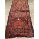A Persian red ground carpet. 108' x 49'