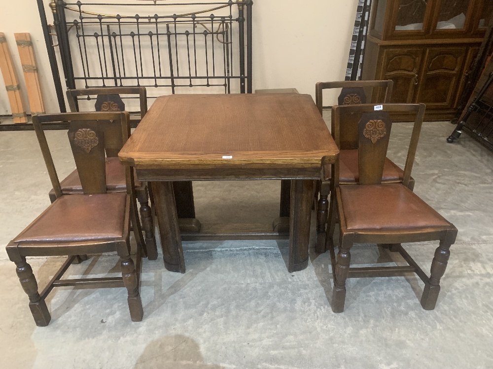 A mid 20th century oak drawleaf dining table and four chairs