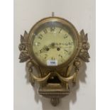 A 19th century carved giltwood cartel clock with French brass drum movement striking on a bell.