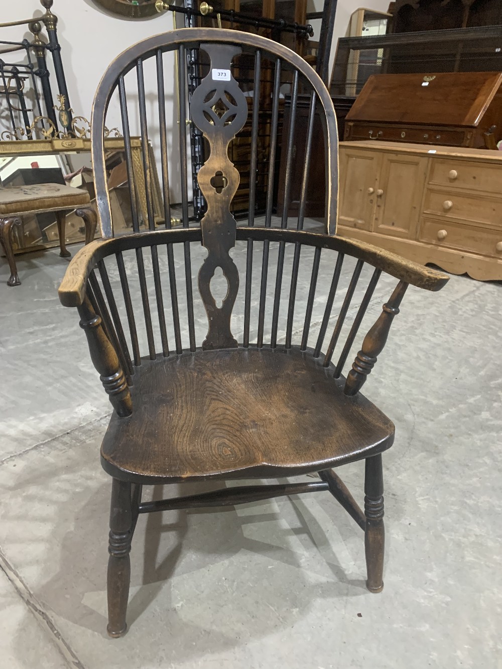 A 19th century Windsor elbow chair on ring turned splayed legs. Reduced in height
