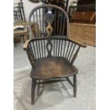 A 19th century Windsor elbow chair on ring turned splayed legs. Reduced in height