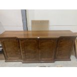 A 19th century mahogany breakfronted buffet, the four ripple grained doors enclosing an