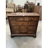 A George III mahogany chest of two short over three long graduated drawers raised on bracket feet.