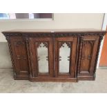 A 19th century oak gothic revival breakfronted side cabinet in the manner of Augustus Welby