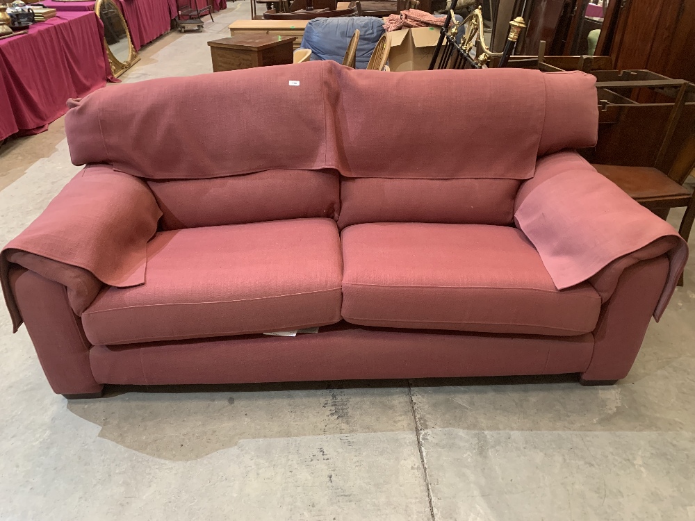 A contempory style sofa upholstered in a pink canvas fabric. 84' wide