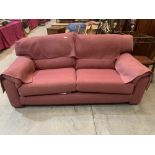 A contempory style sofa upholstered in a pink canvas fabric. 84' wide