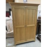 A modern light oak wardrobe enclosed by a pair of panel doors. 45' wide
