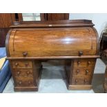 A Victorian mahogany cylinder pedestal desk, the fall enclosing a writing slide, maple veneered