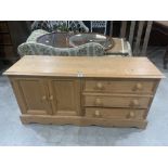 A pine chest of three drawers with cupboard enclosed by a pair of panel doors. 52' wide