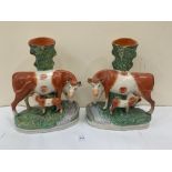 A pair of 19th century Staffordshire cow and calf spill vases. 11' high. One cow with loss to horn