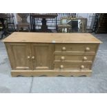 A pine chest of three drawers with cupboard enclosed by a pair of panel doors. 52' wide