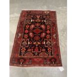 A Persian Hamadan red ground rug. 66' x 42'