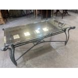 A glass mirror topped and wrought metal based low table. 52'l x 26'w