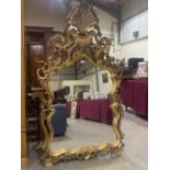 A Venetian baroque style carved giltwood looking glass, the shaped plate with elaborate openwork