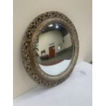 A convex looking glass with pierced acanthus moulded frame. 25' diam.