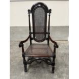 A Carolean period oak elbow chair with caned arched back and seat