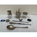 Three silver topped jars; a silver spoon; two buttonhooks etc.