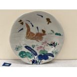 A Chinese plate painted with lilies and a gilded bird. 10' diam.