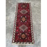 A Persian Karadja red ground carpet runner. 66' x 26'