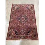 A red ground Hamadan rug. 63' x 42'