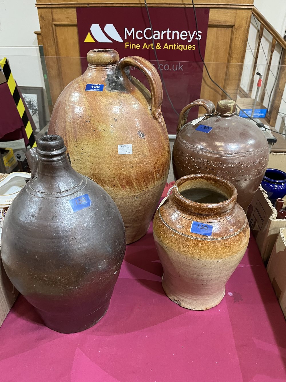 Three large salt glazed earthenware bottle jars and a salt glazed shop pot. (4)