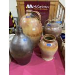 Three large salt glazed earthenware bottle jars and a salt glazed shop pot. (4)