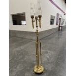 A 19th century brass telescopic candle lamp standard with three lights each with a glass chimney, on