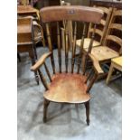 A Victorian kitchen elbow chair on ring turned splayed legs