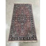 A pink ground eastern rug with centre medallion. 69' x 36'