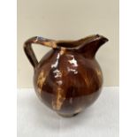 A 19th century pottery ewer glazed in shades of brown. 14½' high